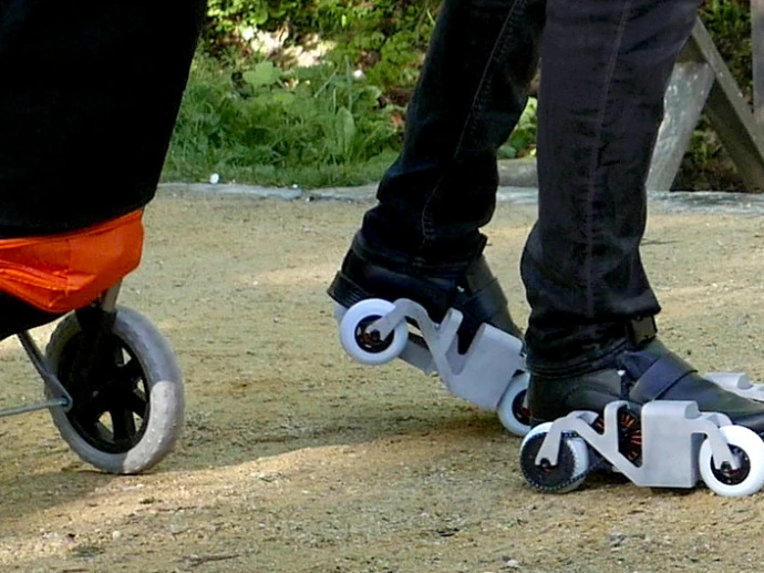 Someone on the KoumKoum electric rollerskate pulling a grocery caddy
